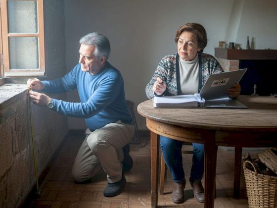Casal a analisar a parede para perceber se vale a pena reforçar o isolamento.