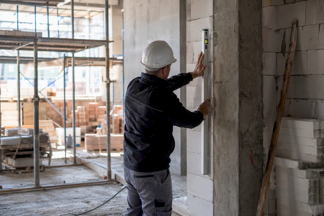 Supervisor a nivelar parede num estaleiro de construção