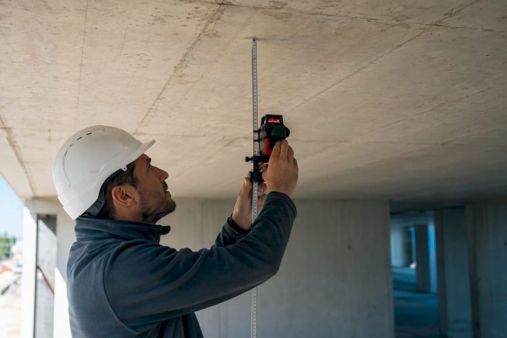 Técnico a medir a flecha numa laje