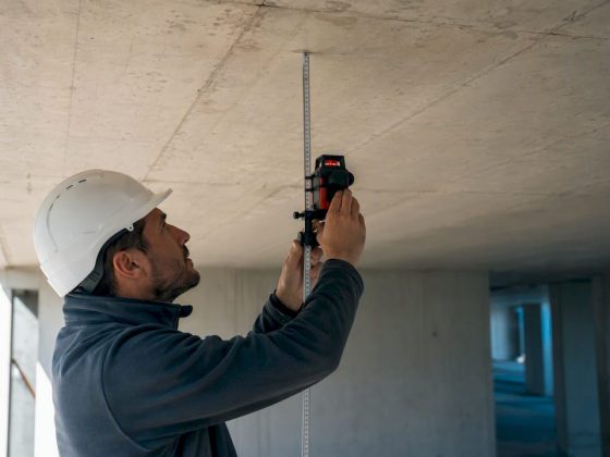 Técnico a medir a flecha numa laje